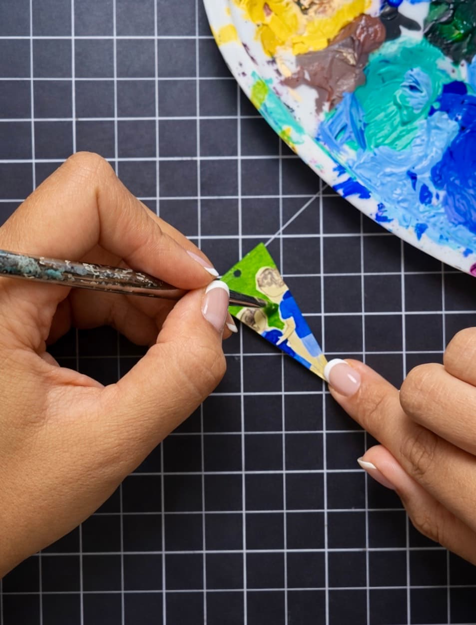 Hand-painting a custom earring in the studio